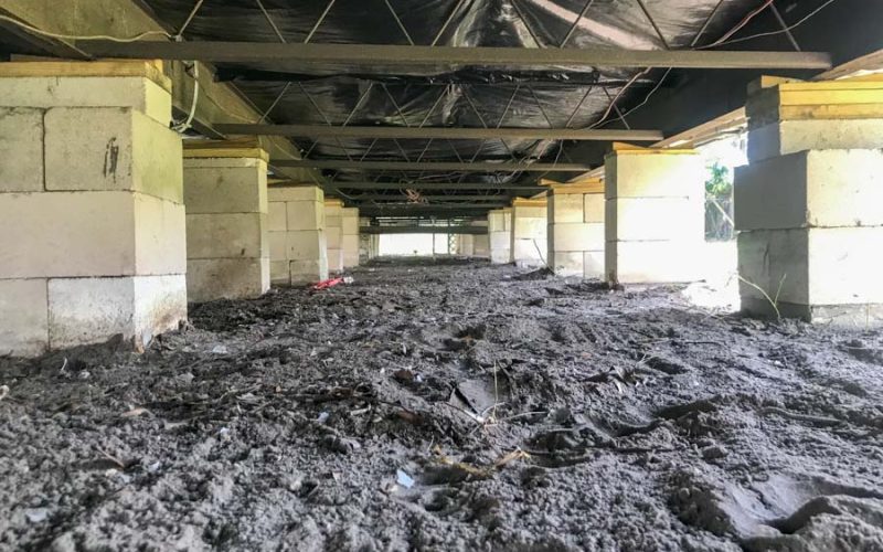 Raw dirt floor and exposed concrete block piers under a home before East Coast Vapor Barrier installation — showing the condition prior to encapsulation and moisture control.
