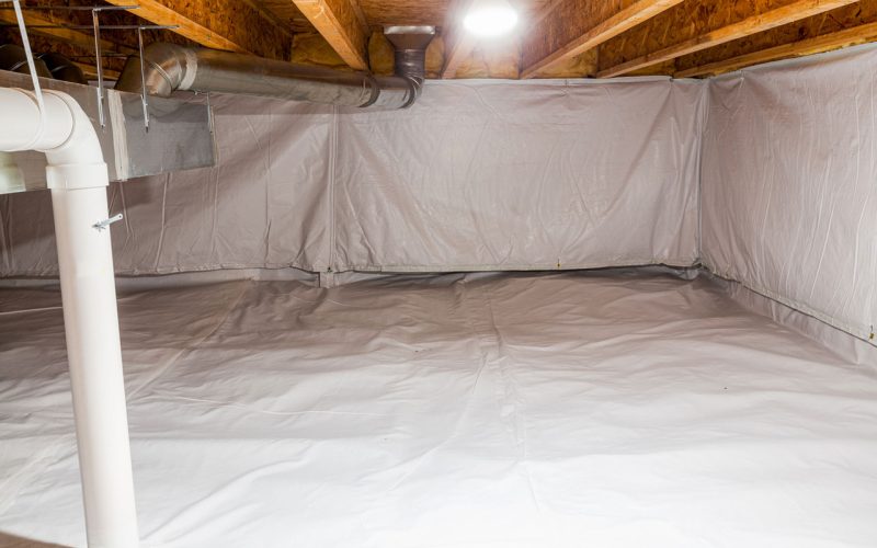 Seamless white vapor barrier installed across the floor and walls of a mobile home crawl space in Florida